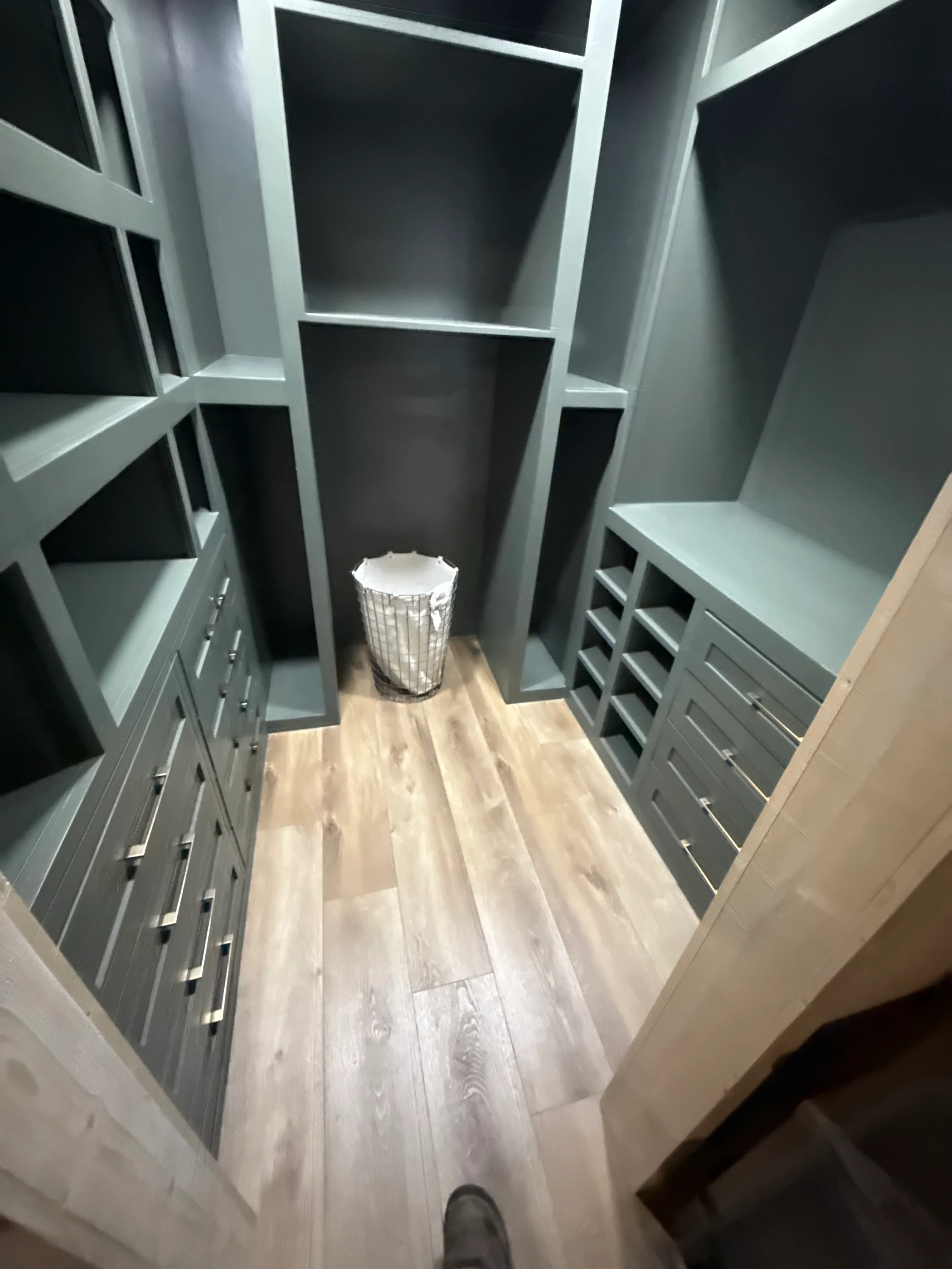 Rebuilt closet with white shelving, wood flooring, and recessed ceiling lights