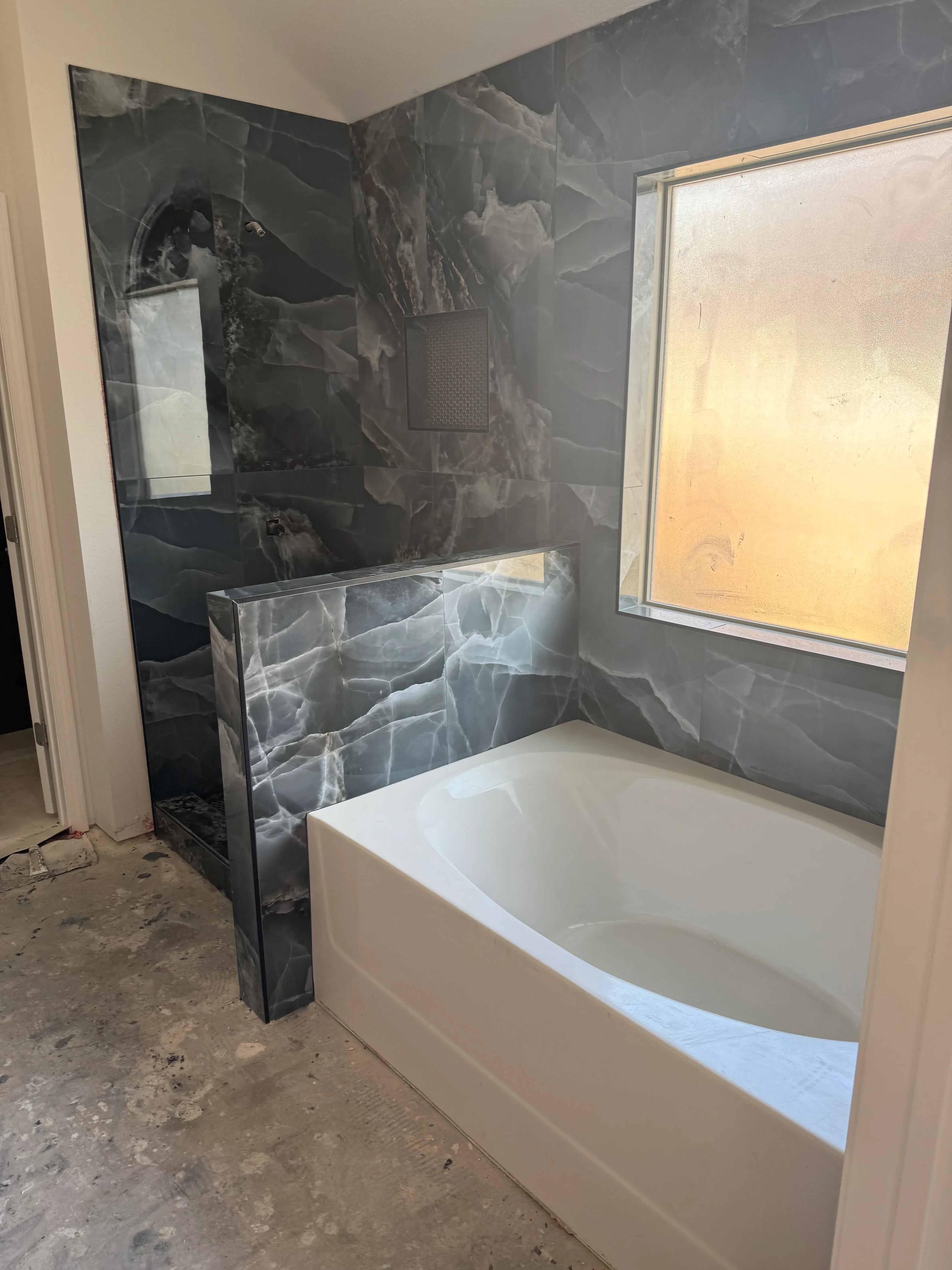 Bathroom interior with removed drywall, exposed framing, and skylight during water damage restoration