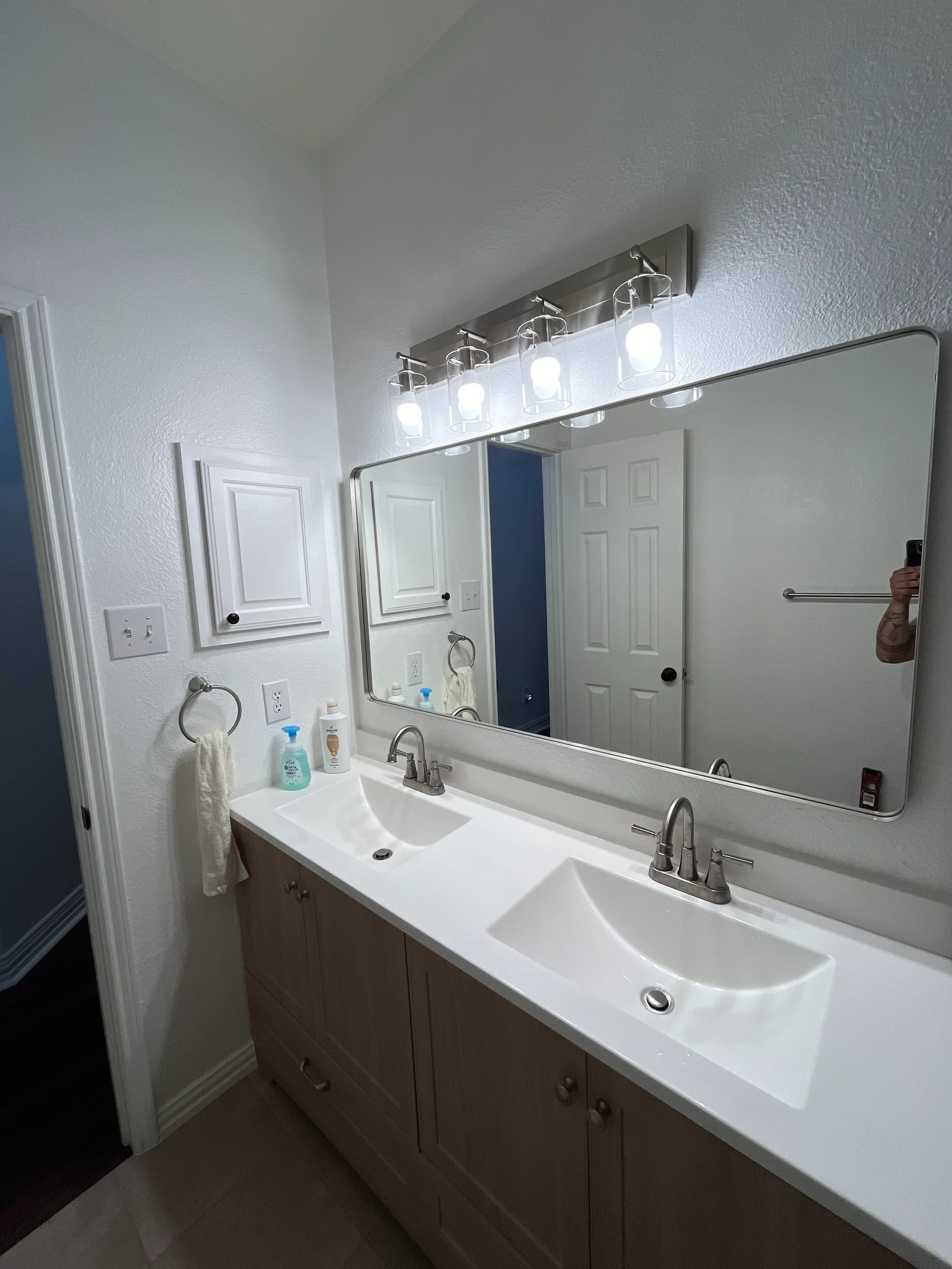Restored bathroom with white walls, glass shower enclosure, chrome fixtures, and recessed LED lighting