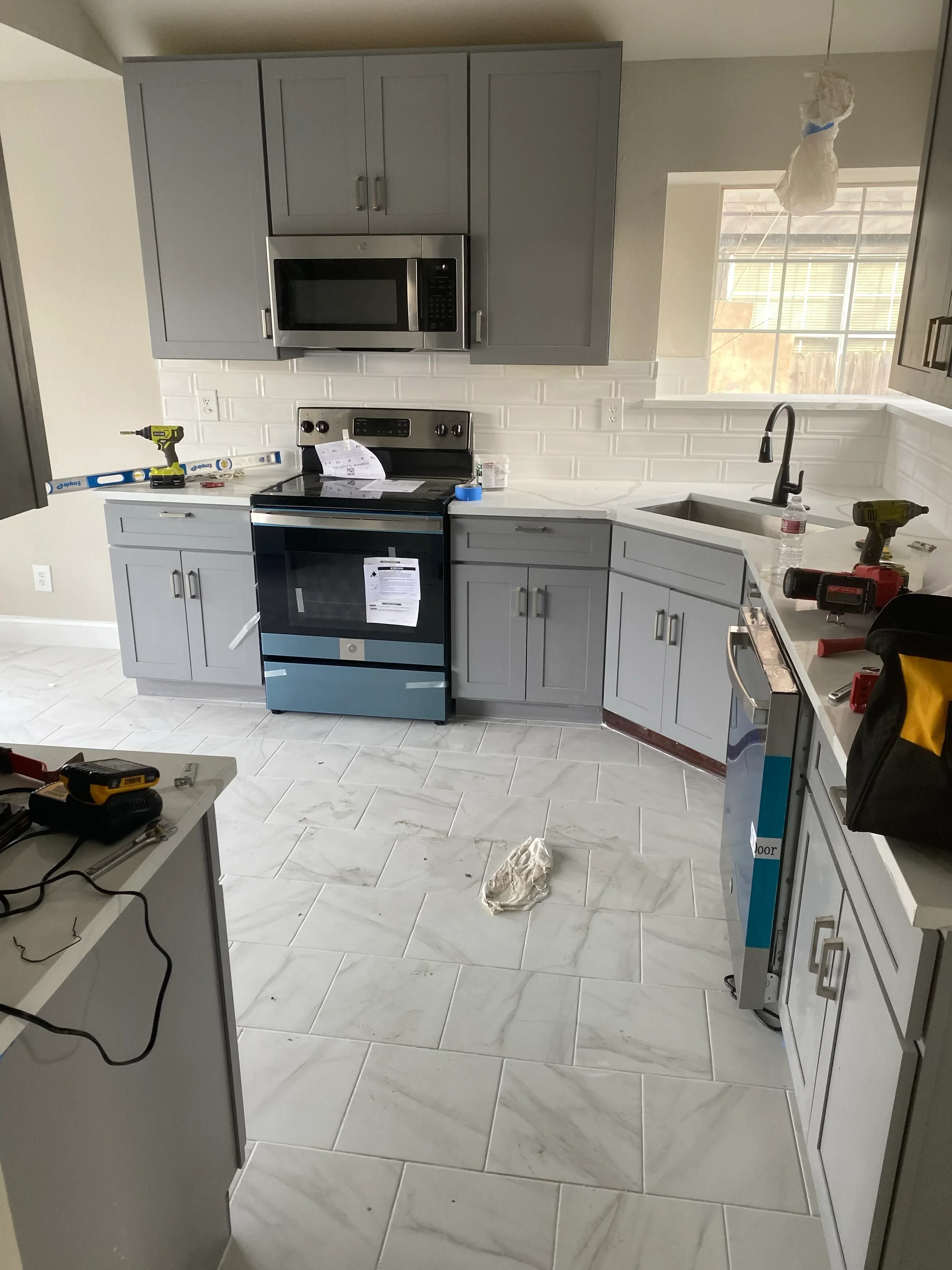 Kitchen with water-damaged drywall, wet flooring, and removed cabinetry during restoration
