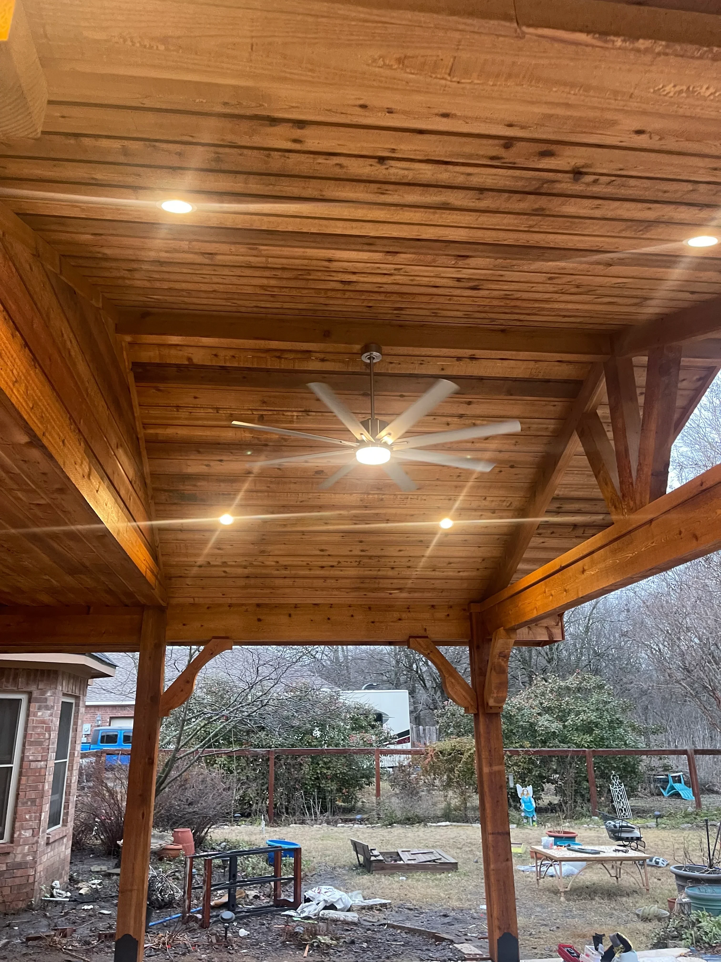 Cedar pergola with exposed beams and recessed lighting fixtures installed
